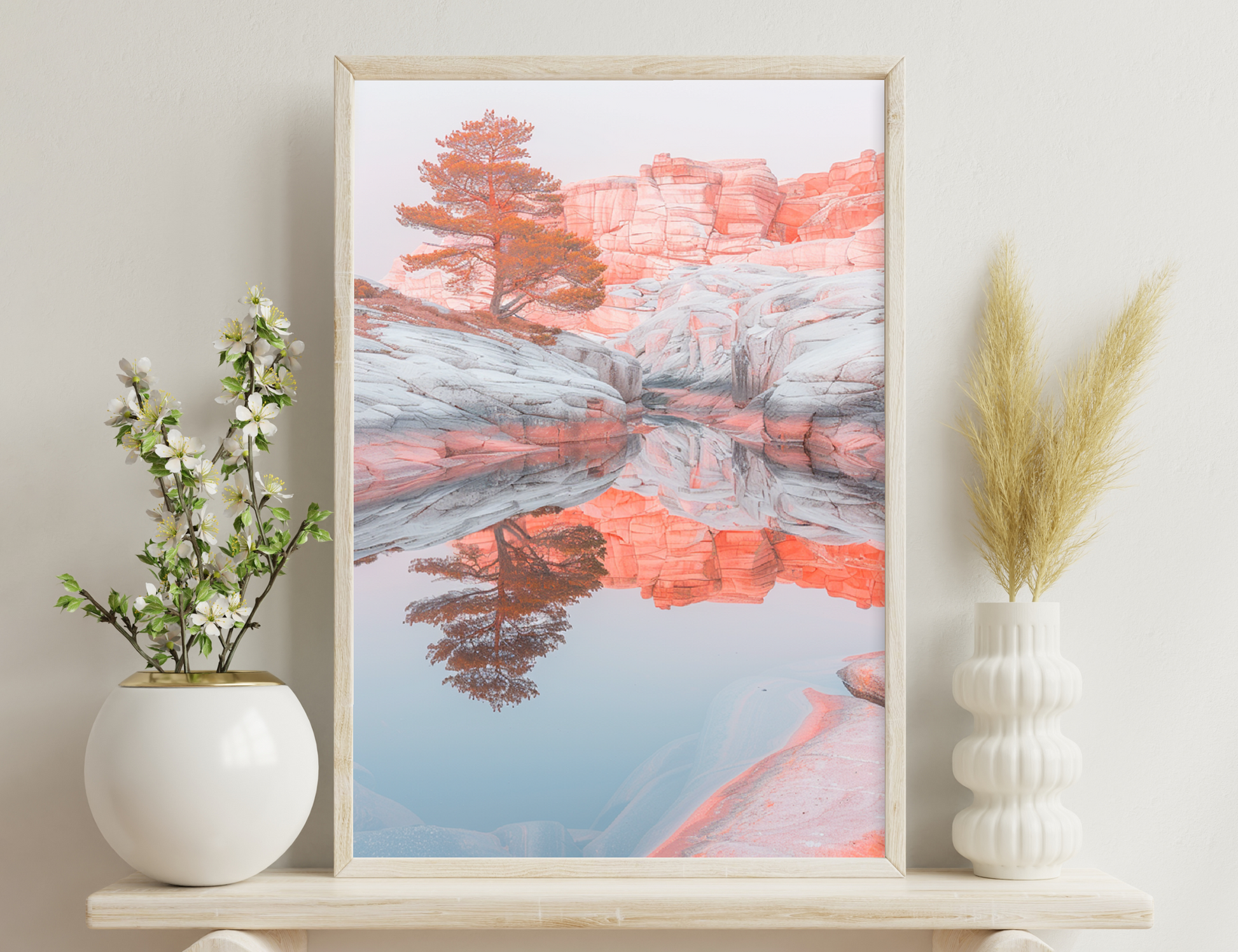 Scenic view of vibrant red sandstone formations reflecting in a tranquil pool, contrasted by fall-colored trees in a serene desert landscape.
