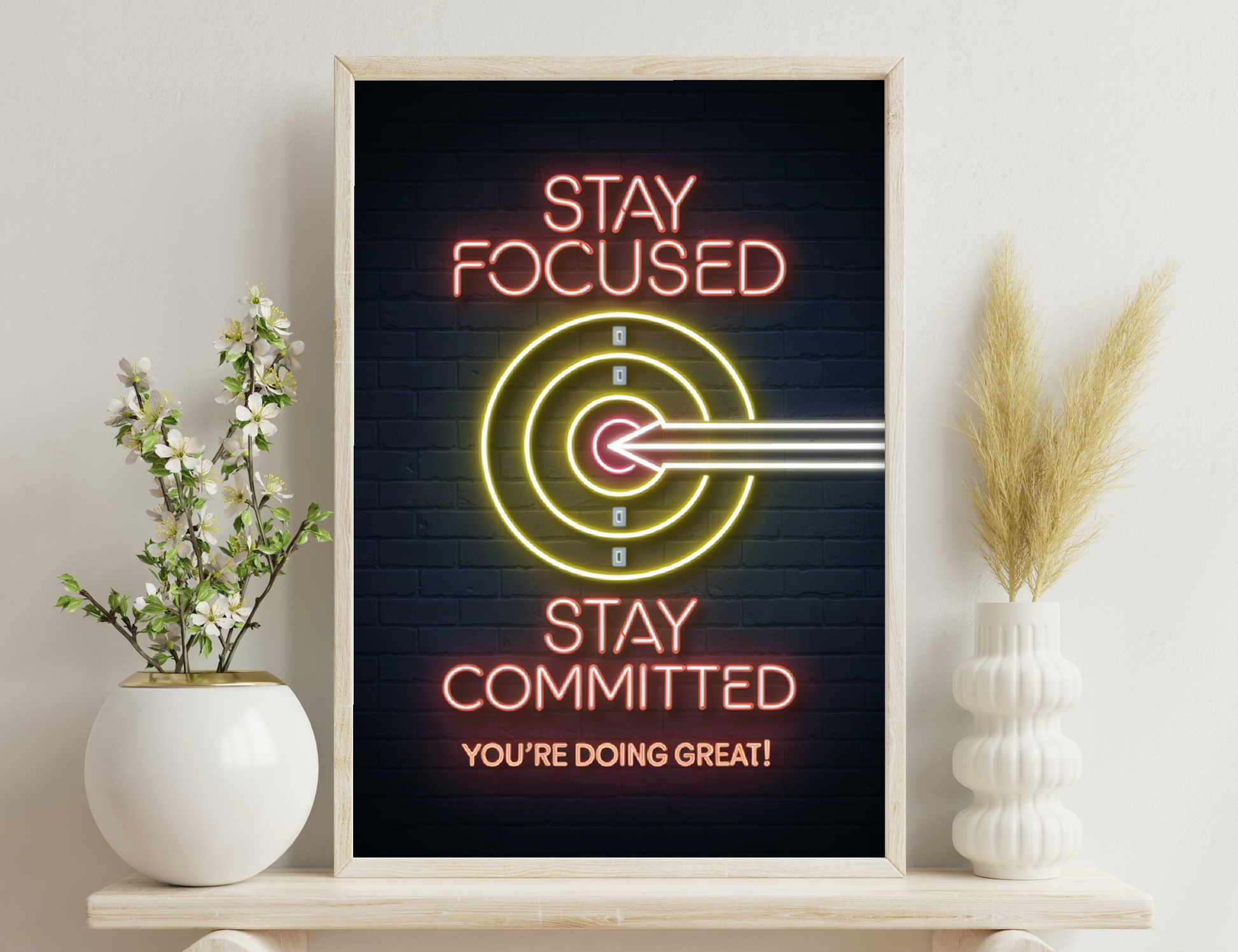 Neon sign with "Stay Focused" and target icon, along with "Stay Committed, You're Doing Great!" in motivational text and colors.
