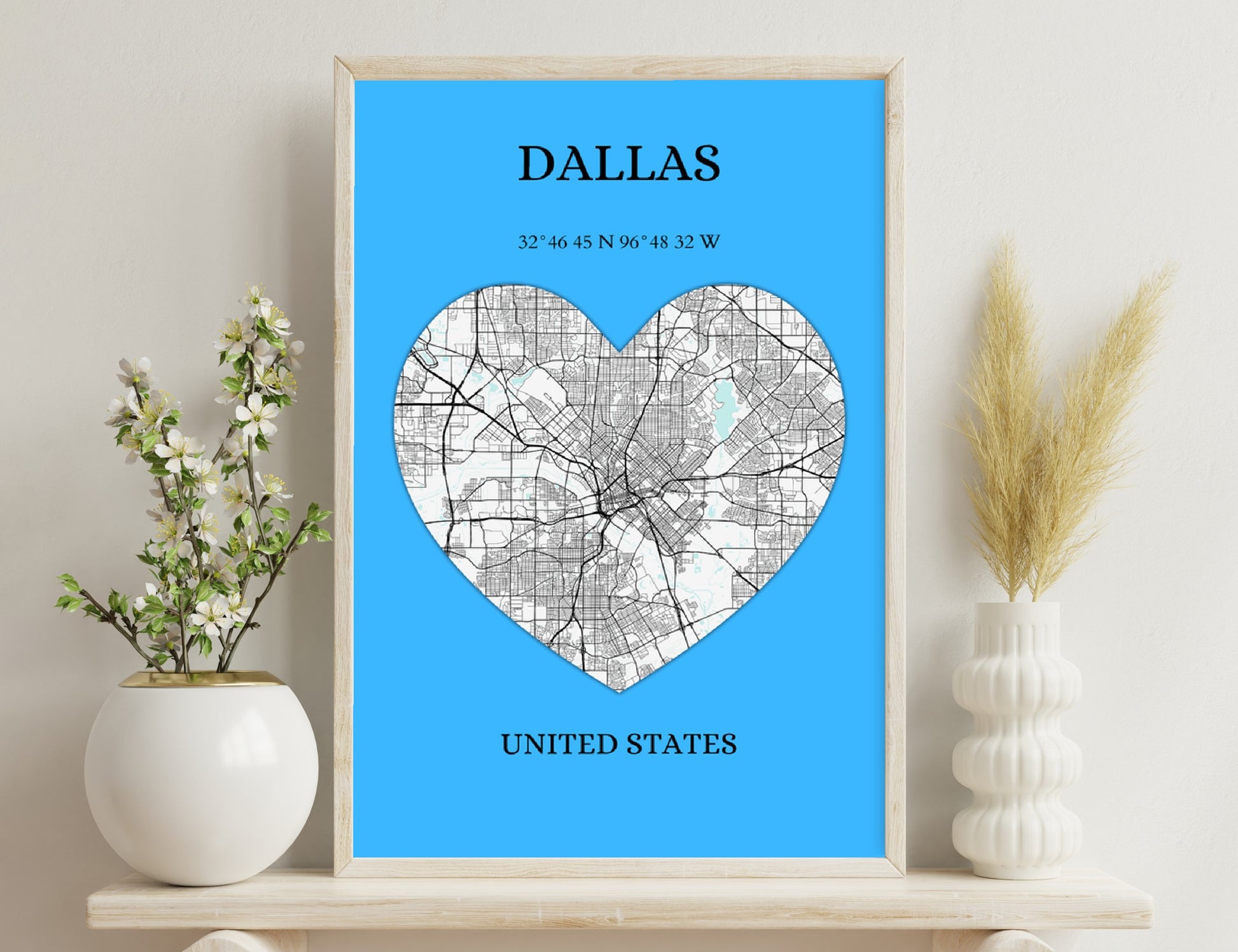 A heart-shaped map of Dallas city streets and roads on a blue background, with the city name, geographic coordinates, and country displayed.
