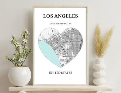 Los Angeles map in heart shape with city streets map on one side and blue ocean on the other, geographic coordinates given
