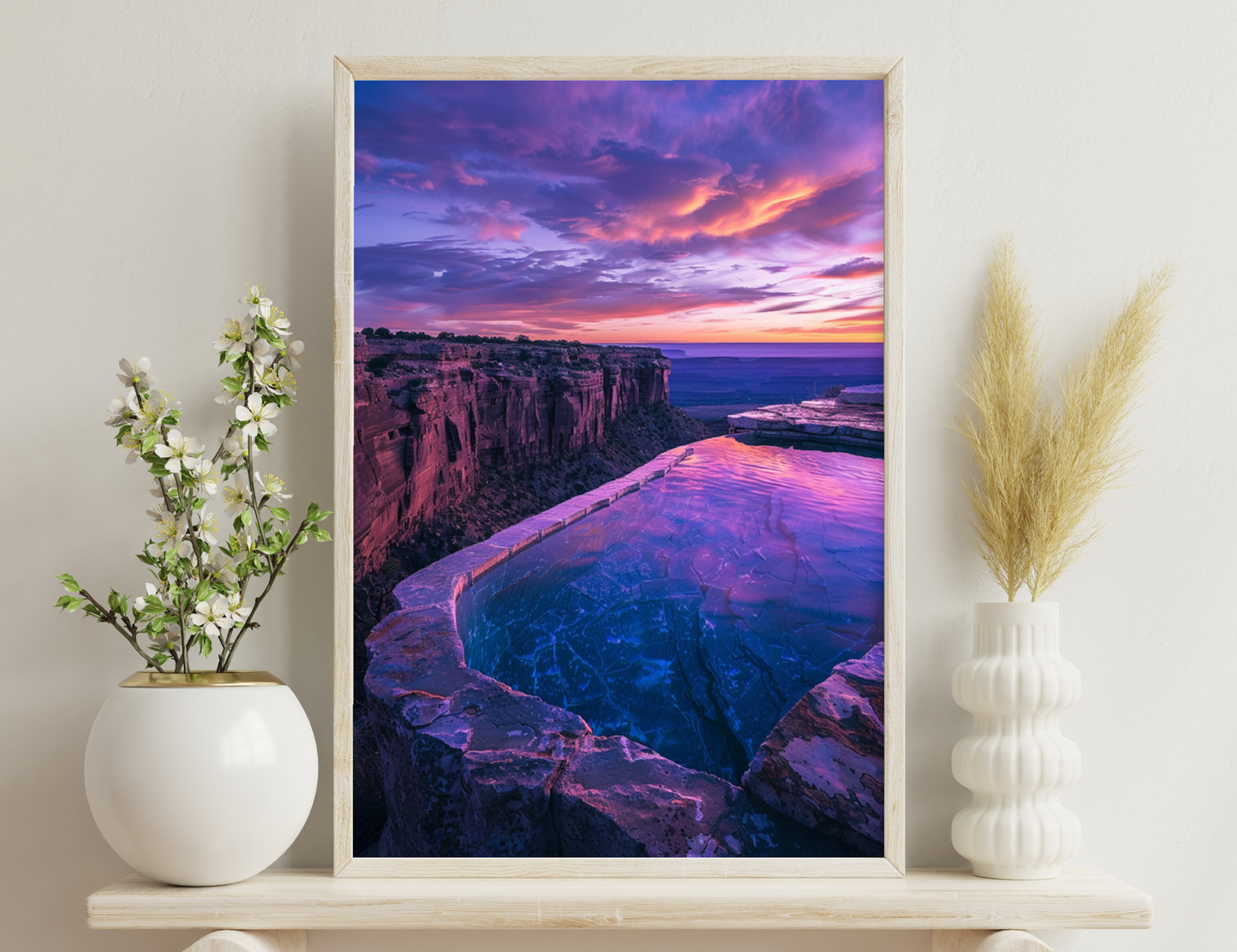 A stunning sunset view of a curved cliff with vibrant orange and purple hues reflecting on a pool of water and the distant horizon over the sea.
