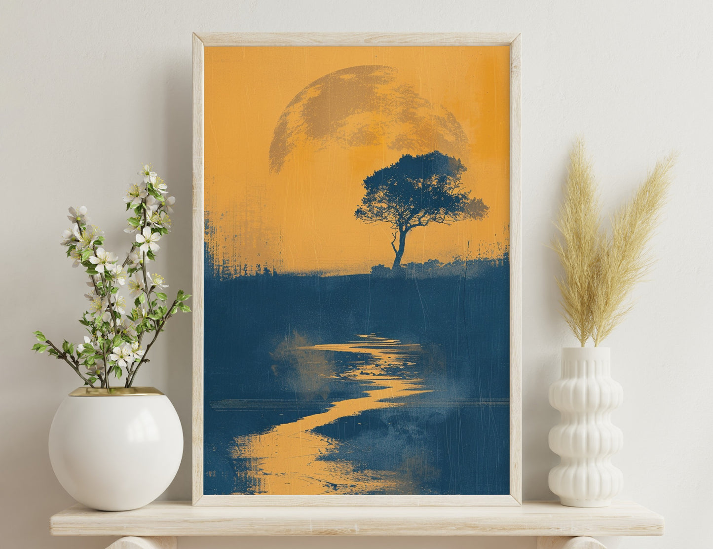 A silhouetted tree stands against an orange sunset or moonrise with a winding river reflecting the warm light.
