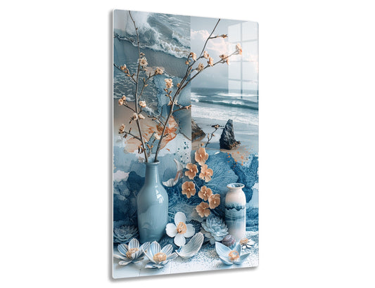 Still life with ceramic vases, dried flowers, and succulents arranged against a coastal backdrop with crashing waves and rocks.
