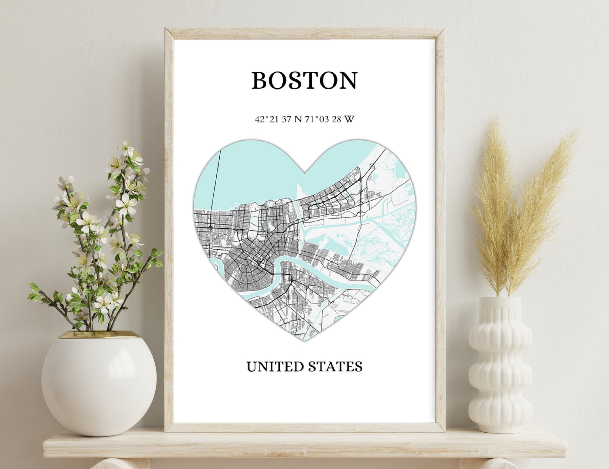 Map of Boston in the shape of a heart, showing the city's street grid and location coordinates, with text labeling "Boston" and "United States" in a minimalist style.

