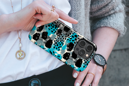 Teal Spots (iPhone MagSafe Case)Elevate your iPhone's protection and style with RimaGallery's Trendy animal print pattern with teal accents on iphone MagSafe Case against a dark backdrop. Enjoy duaRimaGallery
