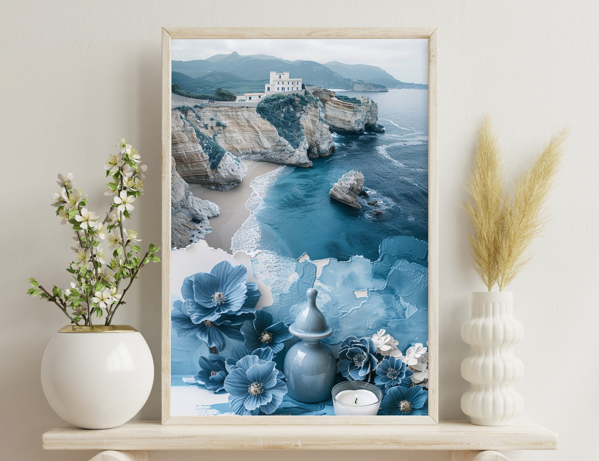 A coastal landscape with a building on a rocky cliff overlooking the sea, combined with decorative blue and white flowers, a vase, and a candle in the foreground, creating a serene, artistic composition.
