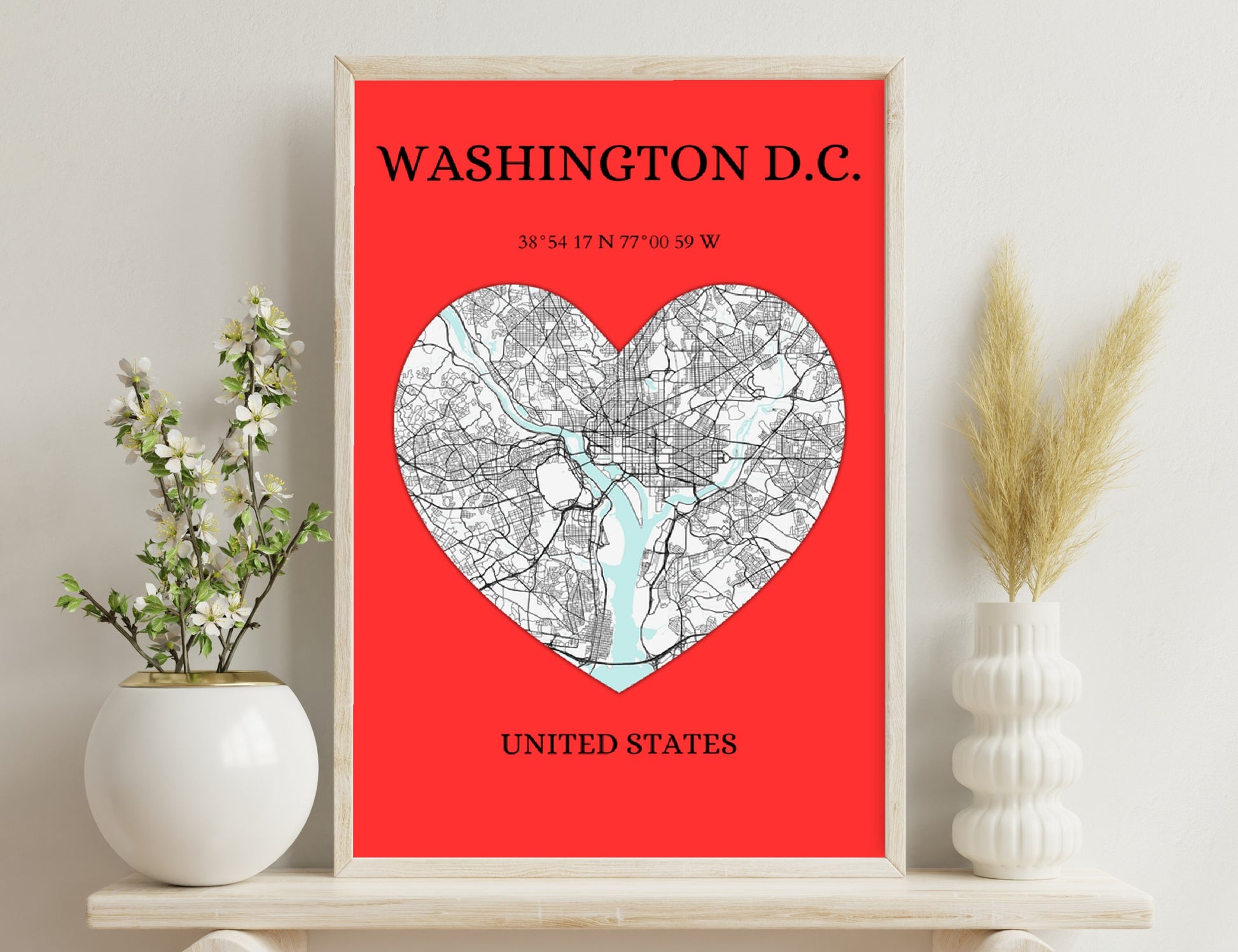 Map of Washington D.C. shaped like a heart with major roads and water bodies shown, along with geographic coordinates and text labeling the city and country, on a red background.
