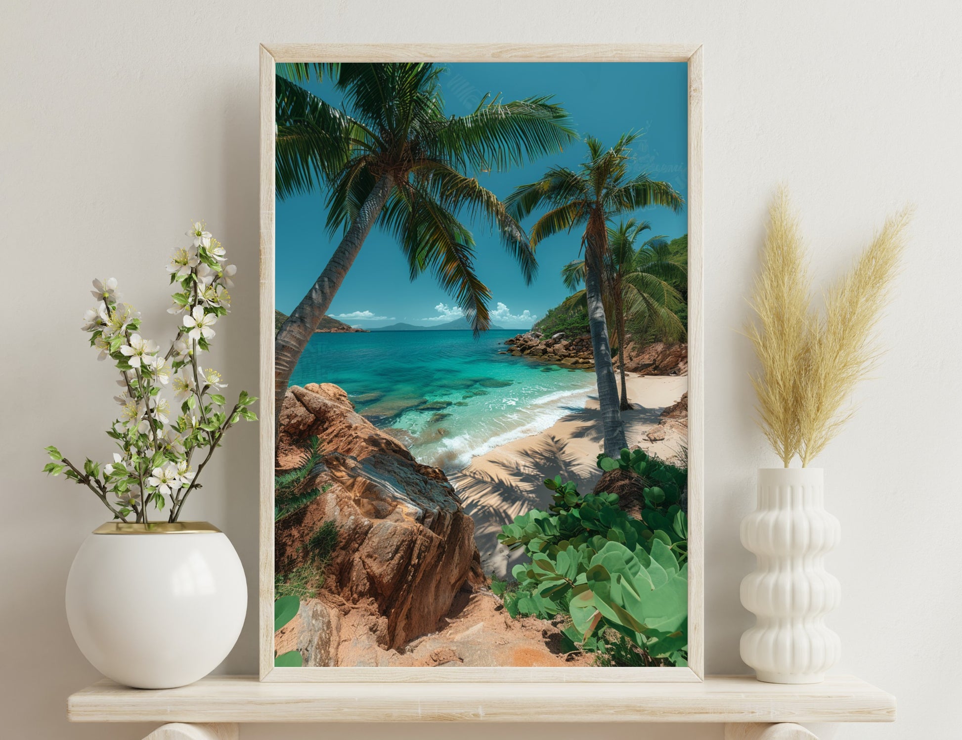 Scenic tropical beach with turquoise waters, sandy shore, palm trees casting shadows, rocky outcrops, and lush green foliage in the foreground.
