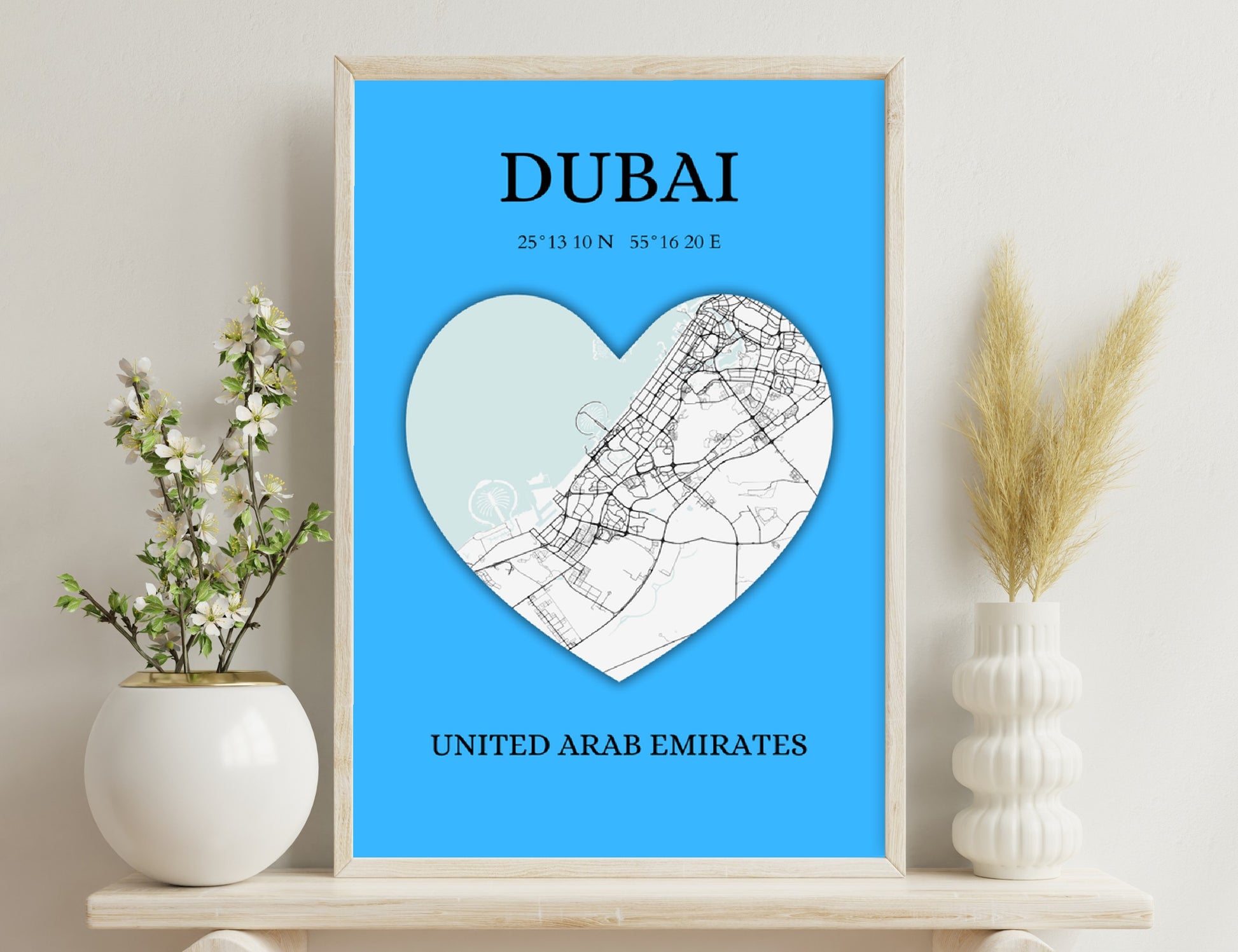 A heart-shaped map of Dubai overlaid on a blue background, with the city's name, GPS coordinates, and country "United Arab Emirates" displayed.
