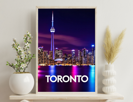 Stunning nighttime skyline of Toronto with the iconic CN Tower illuminated against a vibrant purple and pink sky, reflecting beautifully on the waters of Lake Ontario.
