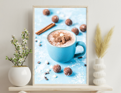 A blue mug filled with hot chocolate topped with whipped cream and cocoa powder, surrounded by cinnamon sticks, chocolate truffles, and scattered cocoa beans on a blue background.
