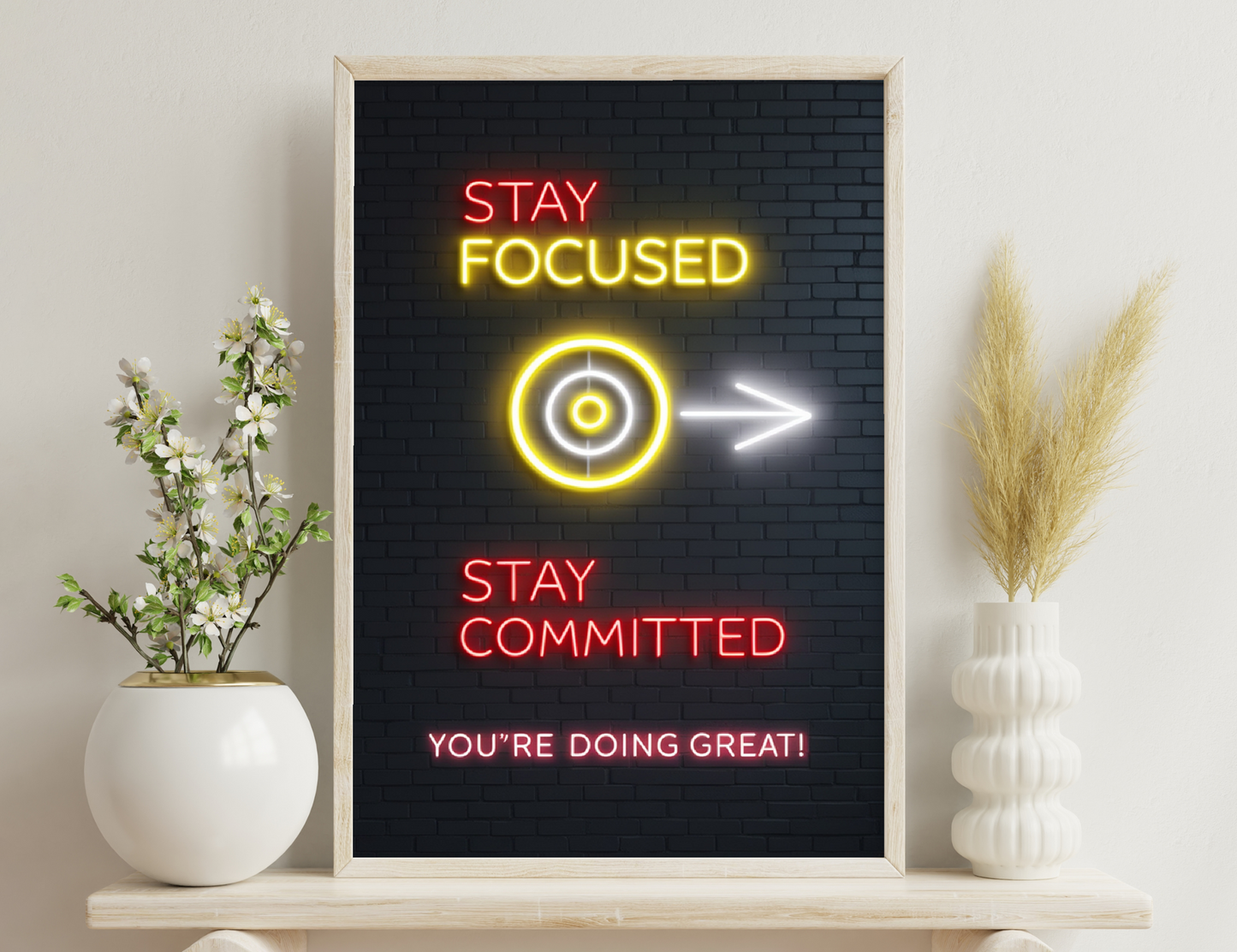 Neon sign on brick wall saying "Stay Focused" with target icon, arrow pointing right, "Stay Committed", and "You're Doing Great!" in motivational message
