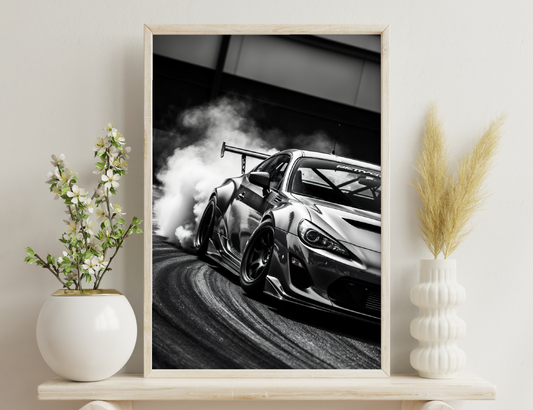 A black and white image of a modified sports car performing a burnout, with thick smoke billowing from the rear wheels. The sleek body contours and low stance of the vehicle are prominently displayed.
