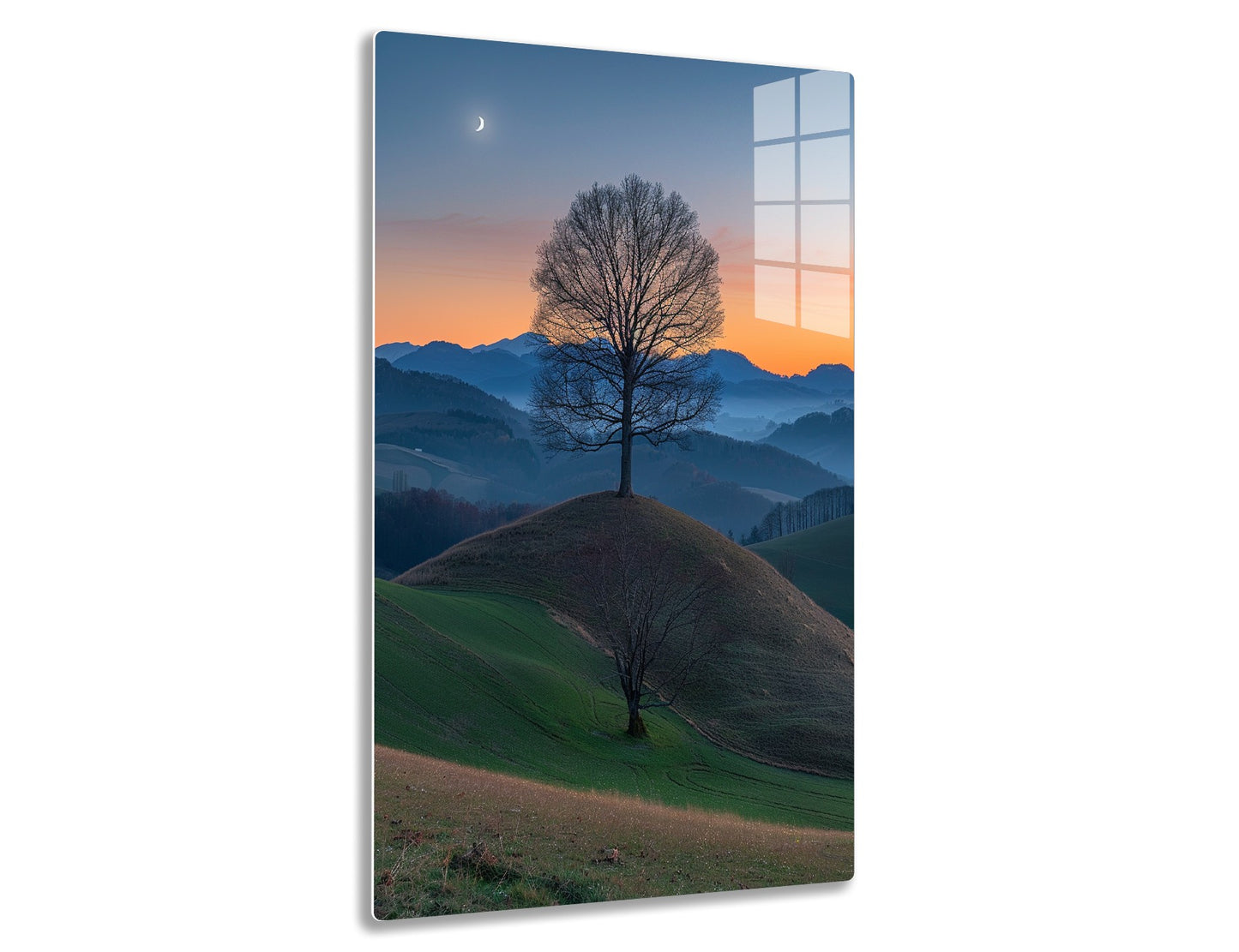 A lone bare tree stands on a hill at sunset, with a crescent moon in the sky and rolling mountains in the distance creating a serene, picturesque landscape.
