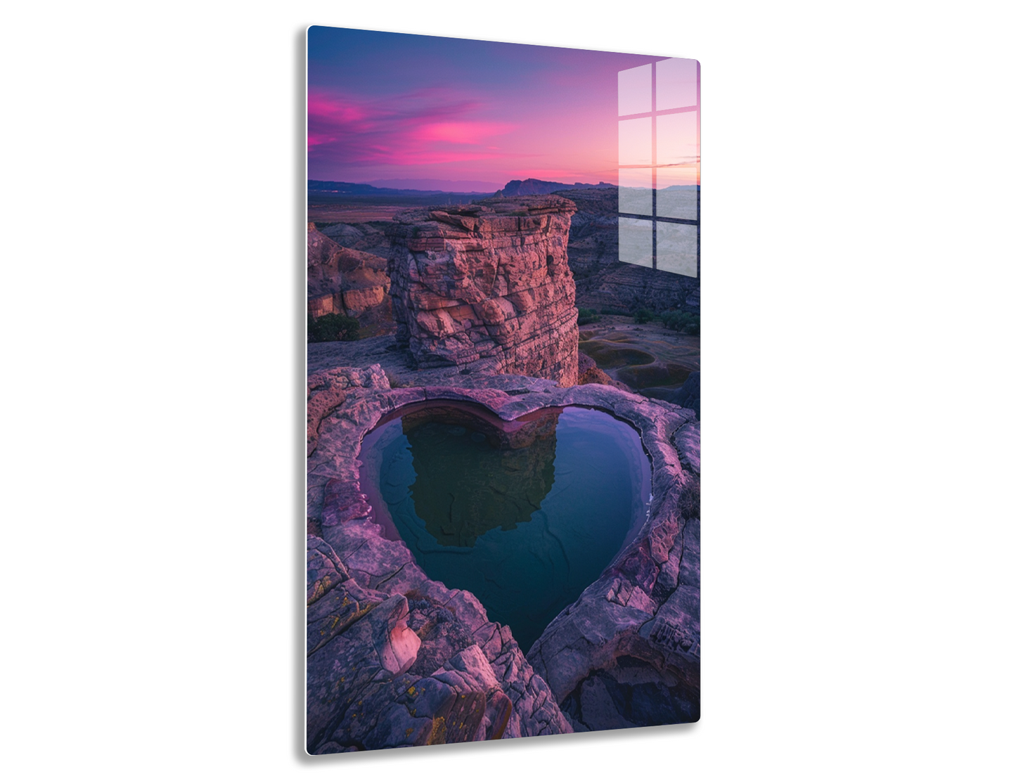 Heart-shaped pool at the edge of a canyon cliff reflecting the vibrant pinkish-purple sunset sky, surrounded by rugged red rock formations.
