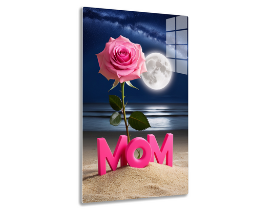 A pink rose blooming against a night sky with a full moon and the word "MOM" spelled out in pink letters on a sandy beach, creating a serene and heartwarming Mother's Day scene.
