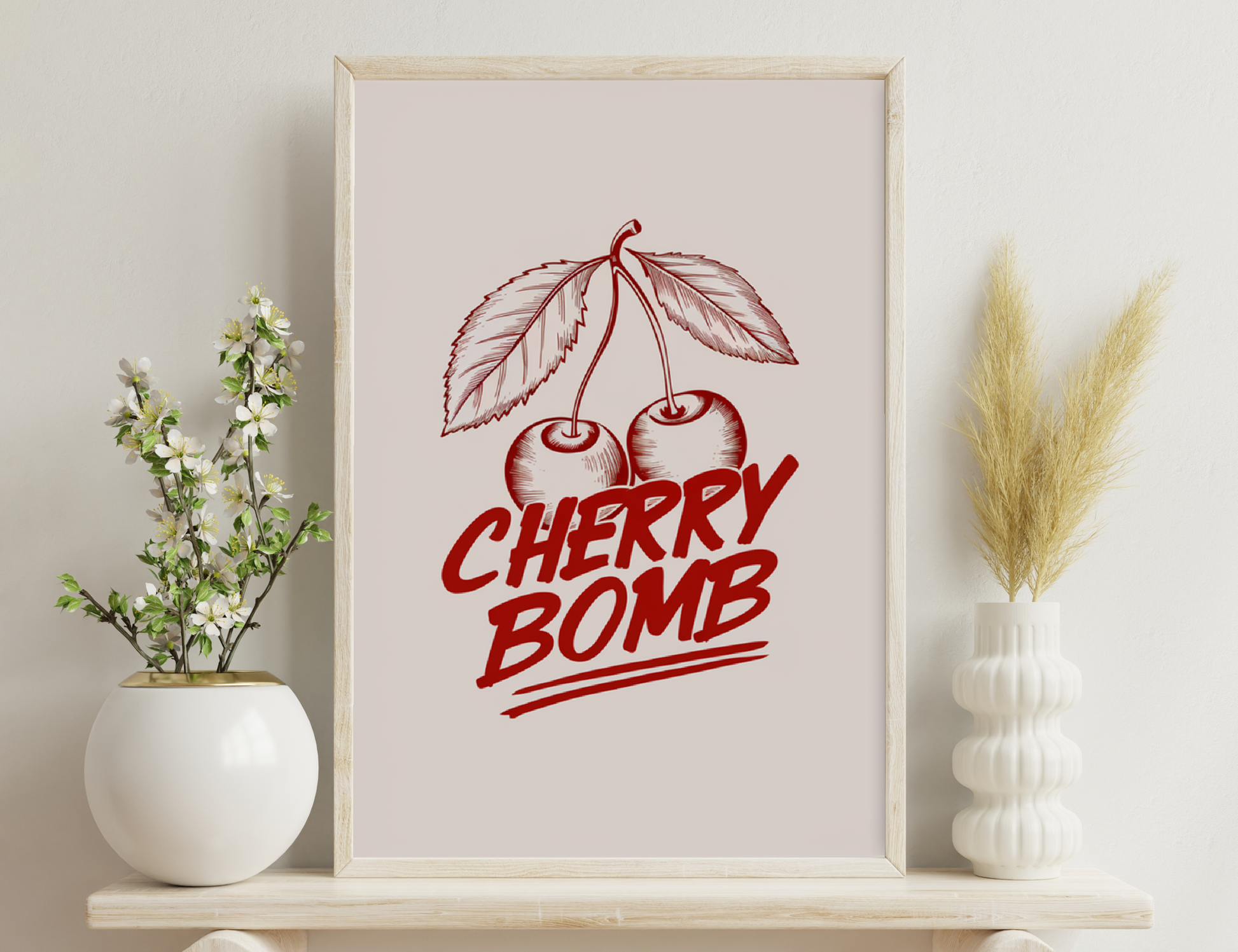Vintage graphic illustration depicting two cherries with leaves and the text "Cherry Bomb" in a stylized red color on a light background.
