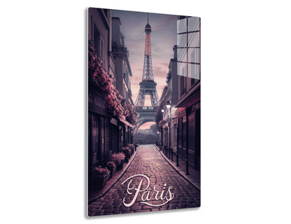 A cobblestone street in Paris lined with buildings overlooking the Eiffel Tower at sunset, with the word "Paris" written in a cursive font at the bottom.
