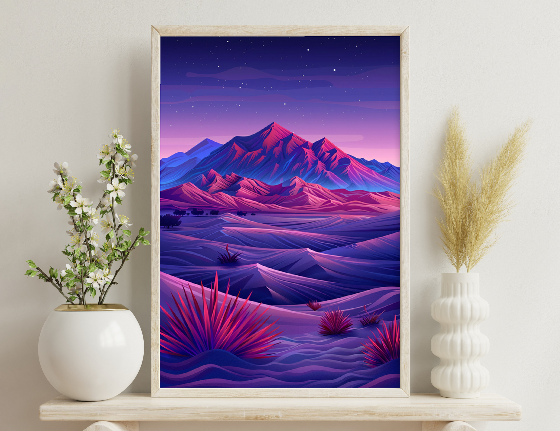 A vibrant landscape at dusk featuring majestic, snow-capped mountains in shades of red and blue against a starry sky, with rolling hills and desert plants in the foreground.
